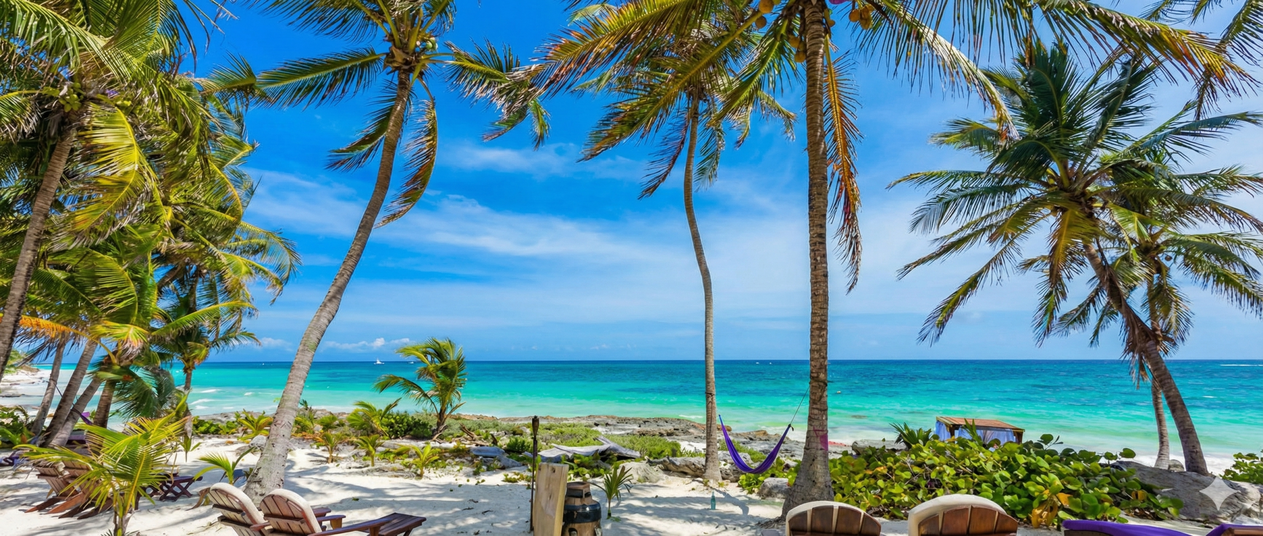 Vista paradisiaca de una playa en la Riviera Maya con palmeras y sillas de madera frente al mar Caribe.