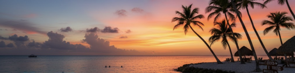 Paisaje costero al atardecer con siluetas de palmeras en una playa de arena blanca y un resplandor turquesa bajo el agua.
